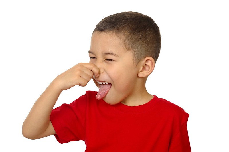 Boy holding his nose because of a bad smell